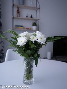 拉彭兰塔Uusi asunto ydinkeskustassa, Wifi, ilmainen pysäköinti的坐在桌子上的白花花瓶