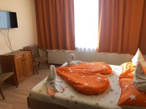 希欧福克城市酒店的酒店客房带两张带橙色床单的床