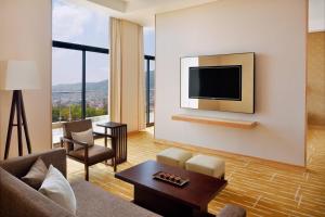 基加利基加利万豪酒店的客厅配有沙发和墙上的电视