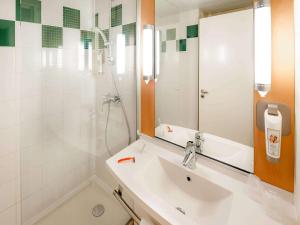 瓦讷宜必思瓦纳酒店的一间带水槽、淋浴和镜子的浴室