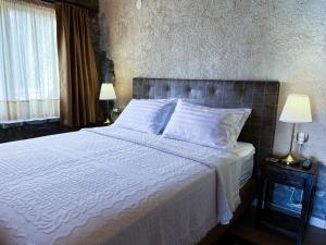 卡斯托里亚The Little Stone House by the Lake的卧室配有一张带白色床单和枕头的大床。