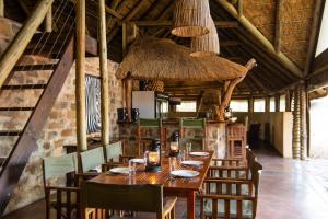 法尔瓦特Bushwa Private Game Lodge的一间带木桌和椅子的用餐室