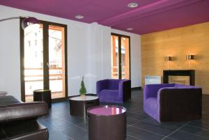 丰罗穆拉格朗日勒匹德卢塞公寓式酒店的客厅配有紫色家具和壁炉
