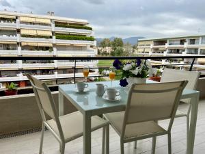 马贝拉Apartamento con vistas y terraza en Guadalmina Marbella的阳台配有桌椅、饮料和鲜花