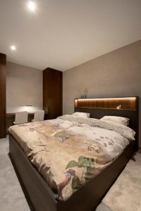 奥德海文利Nuit Blanche的一间卧室配有一张大床,床上有毯子