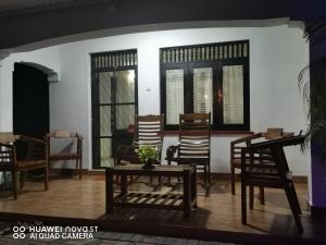 尼甘布Bee Cottage Negombo的客厅配有椅子和桌子