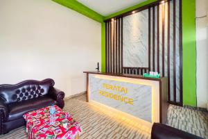 棉兰Teratai Residence Mitra RedDoorz的客厅配有真皮座椅和标志