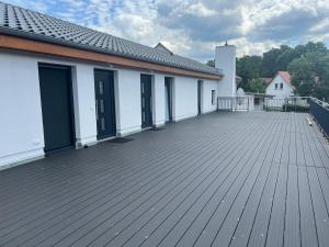 措森New Nomads Ferienwohnung am See的大型木制甲板,设有白色建筑