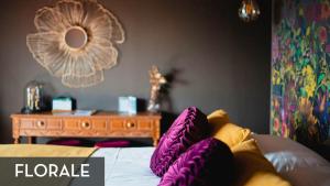 普罗丰德维耶LES 7 MEUSES - Restaurant & Hébergements HÔTELIERS - INSOLITES - WELLNESS - GÎTES的一间卧室配有一张带紫色枕头的床和一张桌子