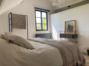 洛默尔Vakantiehuis Zand7的白色卧室配有床和镜子