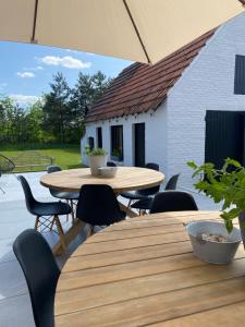 洛默尔Vakantiehuis Zand7的一座带木桌椅的庭院和一座白色的建筑