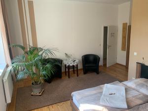 格尔利茨Loensches Gut的一间卧室配有床、桌子和植物