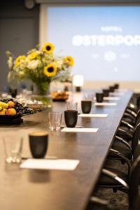 哥本哈根奥斯特波特酒店的长桌,带杯子和盘子的食物和鲜花