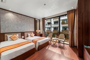 下龙湾Harmony HaLong Hotel的酒店客房设有两张床和一个阳台。