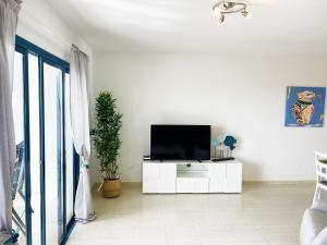 科斯塔特吉塞LOS CHARCOS TERRACE VIEW的一间客厅,客厅的白色橱柜上配有电视
