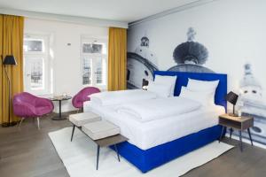 萨尔茨堡Hotel Stein - Adults Only的一间卧室配有大床和粉红色的椅子