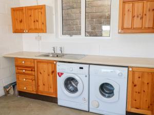 赫尔斯顿The Mariners的厨房配有洗衣机和水槽