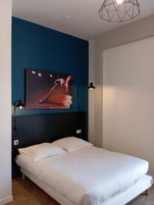 亚眠Nemea Appart Hotel Coliseum Amiens Centre的一间卧室设有一张蓝色墙壁的大床