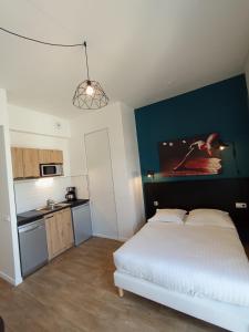 亚眠Nemea Appart Hotel Coliseum Amiens Centre的卧室配有白色的床和蓝色的墙壁