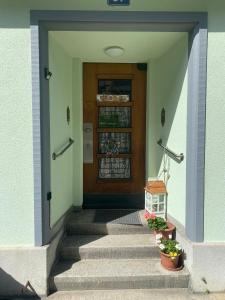 巴塞尔奇奇住宿加早餐旅馆的一座房子的前门,有楼梯和植物