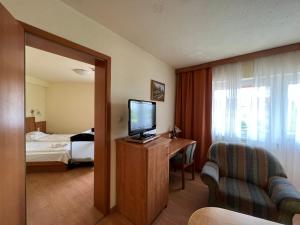 佐洛卡罗斯Aqua Therm Hotel的酒店客房设有电视和卧室