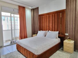 拉巴特Appartement la gare Rabat ville的一间卧室配有一张大床和木制床头板