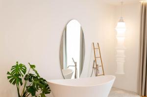 陶尔米纳Neró Rooms的浴室配有白色浴缸和镜子