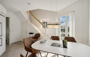 博恩瑟3 Bedroom Awesome Apartment In Bogense的一间配备有白色桌椅的用餐室