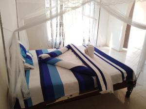 卡萨马Threshold Lodge的窗户客房内的一张带条纹毯子的床