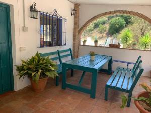 马拉加Casa Rural Los Almendros的天井上摆放着一张蓝色的桌子和两把椅子