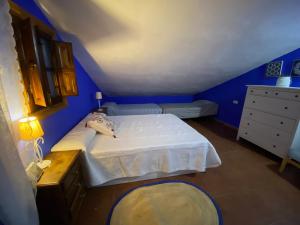 马拉加Casa Rural Los Almendros的一间蓝色卧室,配有一张床和一个梳妆台