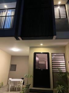 CogonMactan Cebu Guesthouse - ideal for family or friends的一间有黑色门和一张桌子的房子
