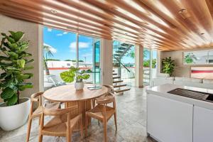 WickhamThe Urban Resort - A Mediterranean-style Group Haven across Two Homes的厨房以及带桌椅的用餐室。