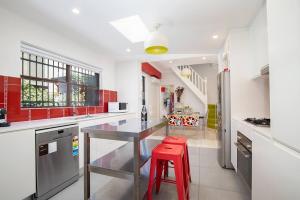 纽卡斯尔Times Square Terrace - Vibrant Charm in Newy's Heart的一间厨房,配有红色橱柜和红色凳子