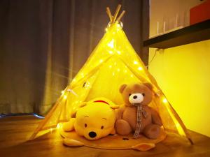 诗巫Hanns&FreeWIFI&Washer+Pool@SunshineComfortHMStay3的两个泰迪熊坐在地上的帐篷下