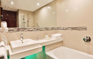 约翰内斯堡约翰内斯堡罗斯班克假日酒店的浴室配有盥洗盆、镜子和浴缸