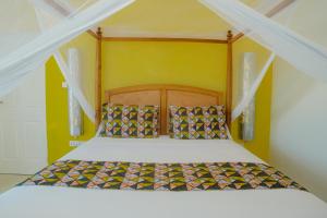 江比阿Villa Citrus Zanzibar的一张带木制床头板的床