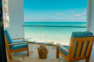 江比阿Villa Citrus Zanzibar的一间设有两把椅子的客房,享有海滩美景