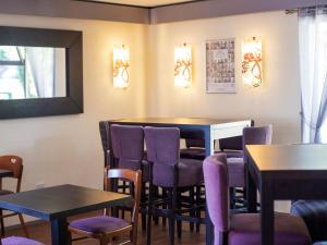 朗科恩钟楼朗科恩酒店的一间用餐室,配有紫色的椅子和桌子