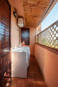 圣卢里亚Casa a schiera con giardino a pochi passi dal mare的一间带水槽的浴室和一个阳台