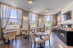 阿朗松德杜克斯酒店的餐厅设有桌椅和窗户。