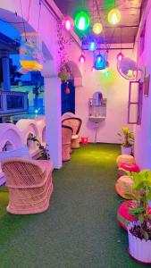 马图拉Manavi Home Stay的一间设有粉色和绿色灯光及椅子的房间