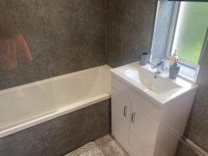 格拉斯哥Clavens House的浴室配有盥洗盆和浴缸。