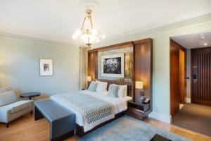 伊斯坦布尔伊斯坦布尔凯悦公园酒店 - 马茨卡帕拉斯的一间卧室配有一张床、一张沙发和一个吊灯。