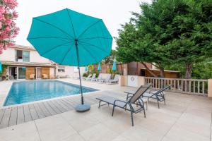圣特罗佩杏仁住宿加早餐旅馆的游泳池旁的天井配有椅子和遮阳伞。