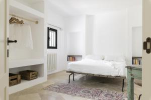 奥斯图尼Trullo Vicino al Mare的白色卧室配有床和桌子