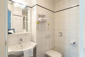 阿朗松德杜克斯酒店的白色的浴室设有水槽和卫生间。