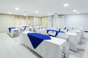 San PedroApartotel Tairona的配有白色桌椅和蓝色桌子的房间