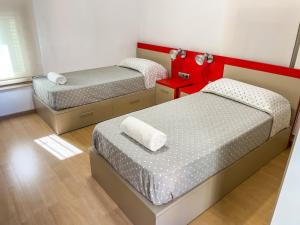巴塞罗那Leevin Student Barcelona的红色色调的小客房内的两张床