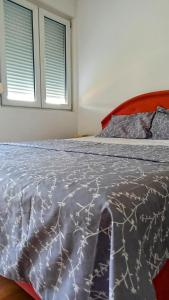 波德戈里察Central Home的一间卧室配有一张大床、一个被子和两个窗户